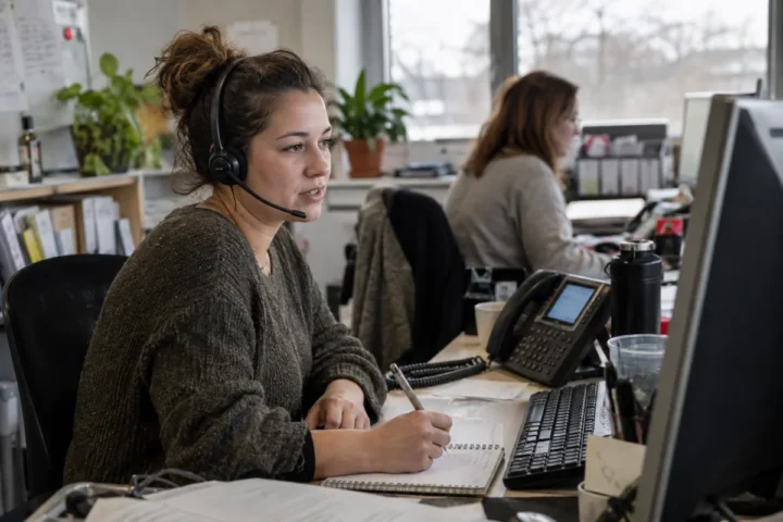 Reception employee testing a small business phone call menu with a headset