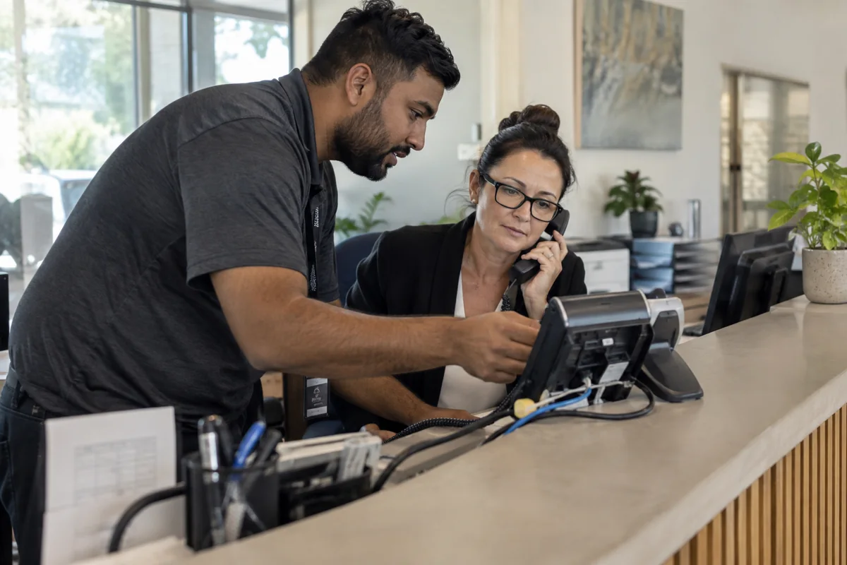 Office administrator and technician coordinating a business phone number transfer