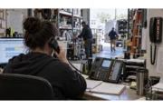 Warehouse dispatcher handling customer calls during a busy shift
